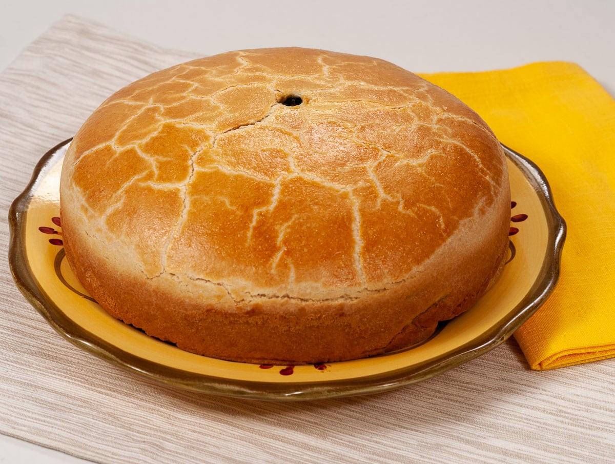 The baked Torta Rustica sits on a bold plate with a yellow napkin.
