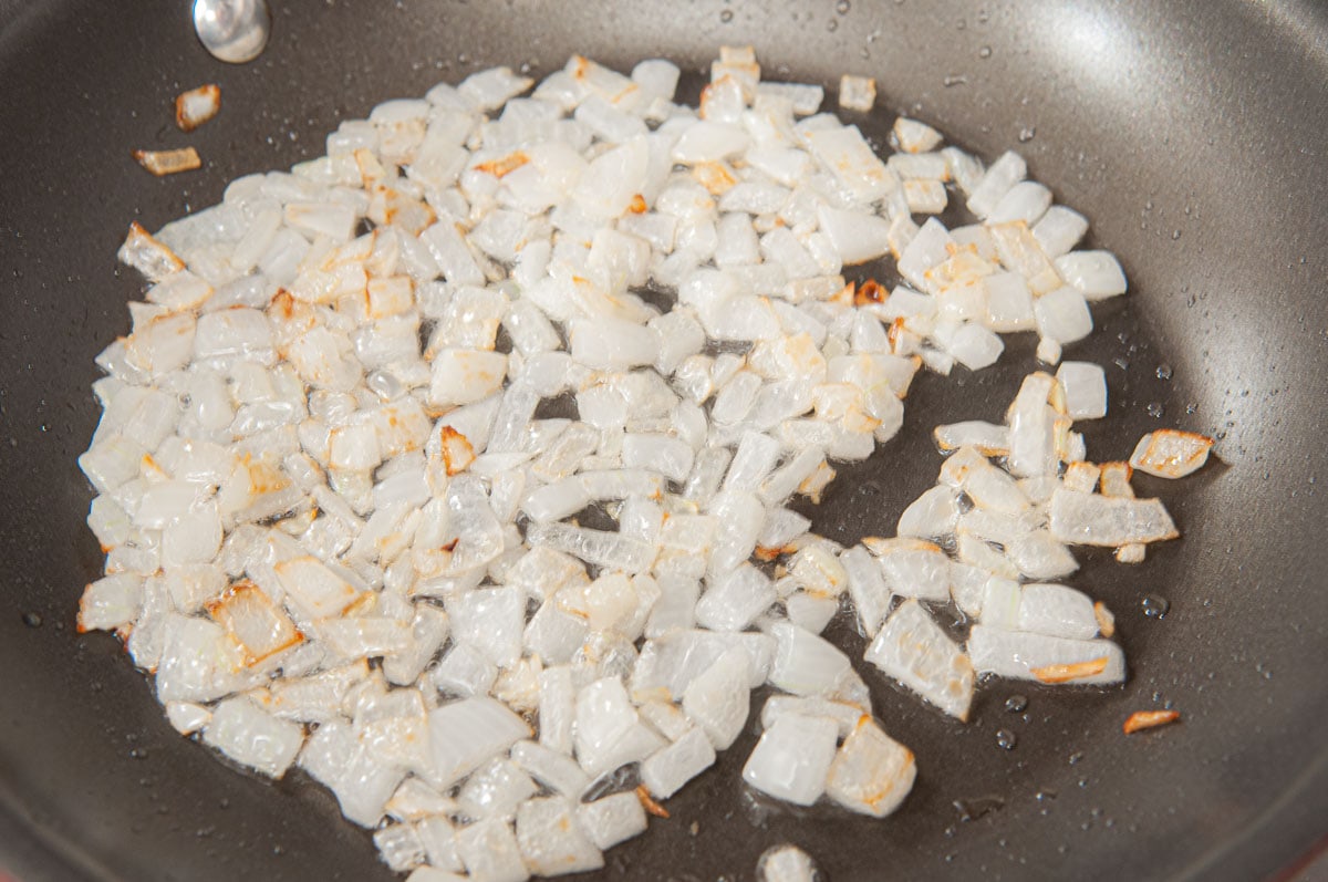 Diced onion, cooking in a black pan. 