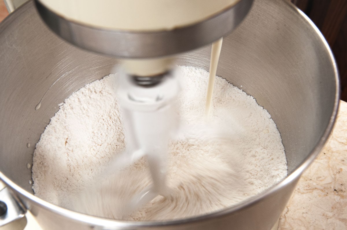 With the mixer running, the cream is poured in.