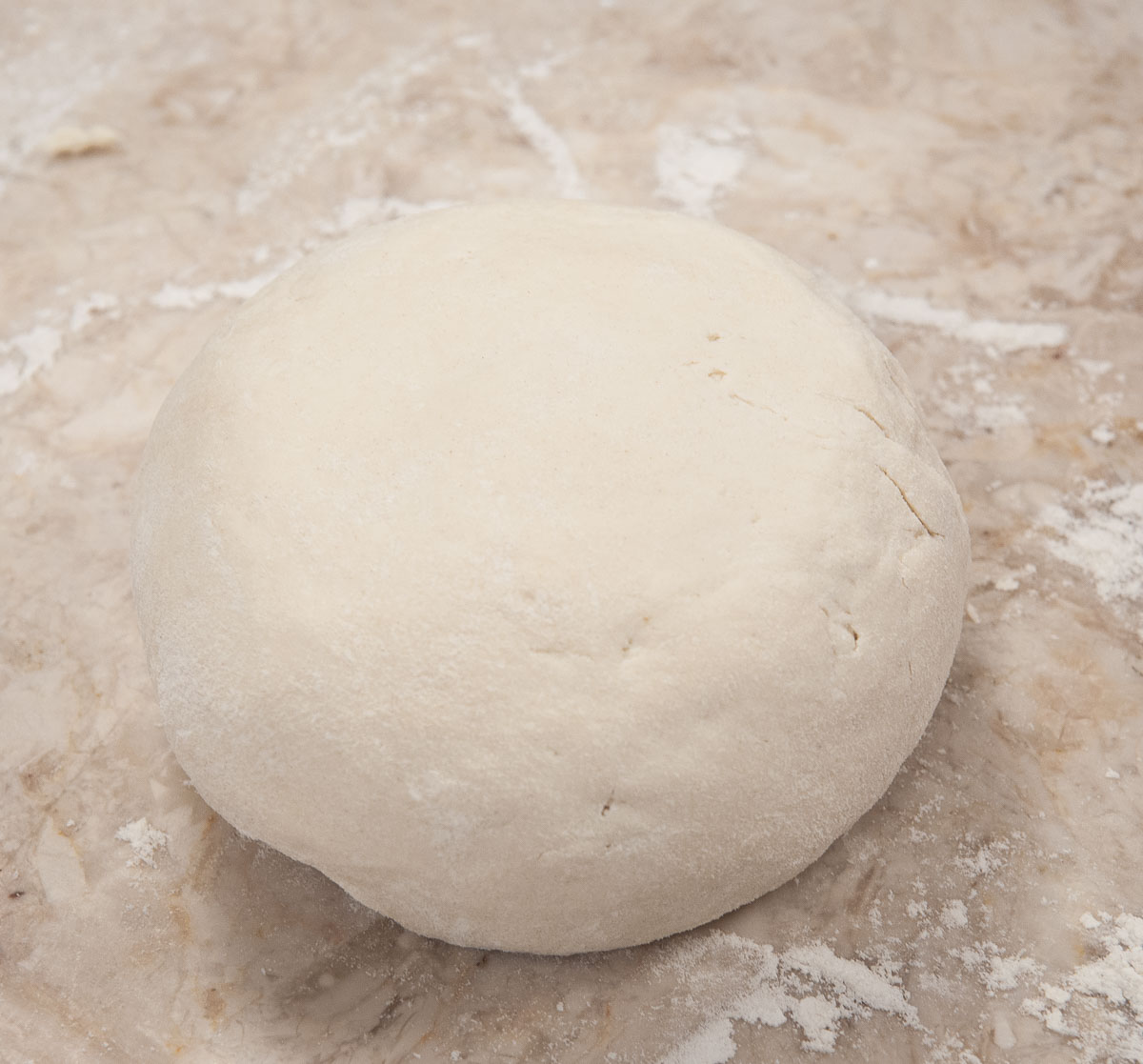 The dough is removed from the mixer and shaped into a ball.