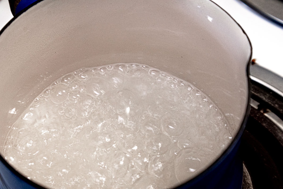 Syrup ingredients water and granulated sugar boiling in a small pan.