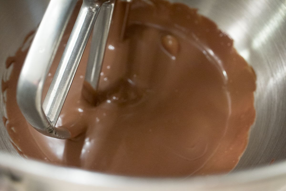 The cold ganache is placed in the bowl of a mixer.
