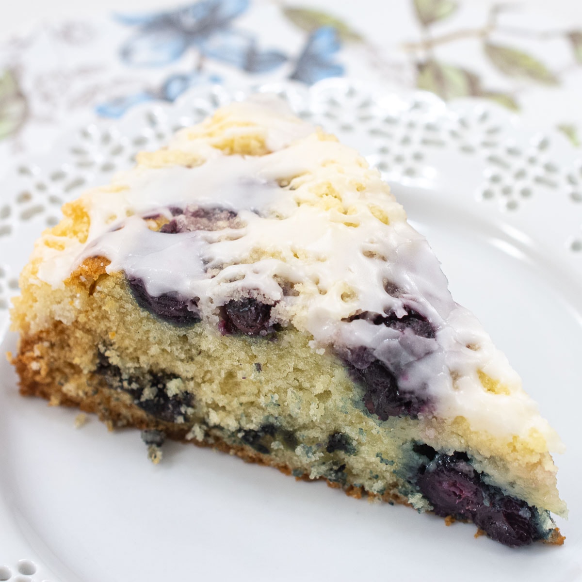 A slice of blueberry crumb coffeecake on a white plate.