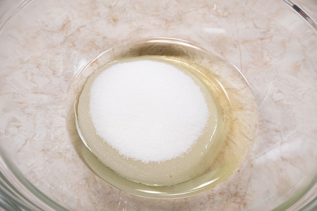 The oil and sugar are combined in a medium size bowl.