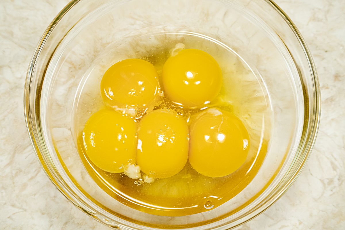 Whole eggs and yolks in a bowl.