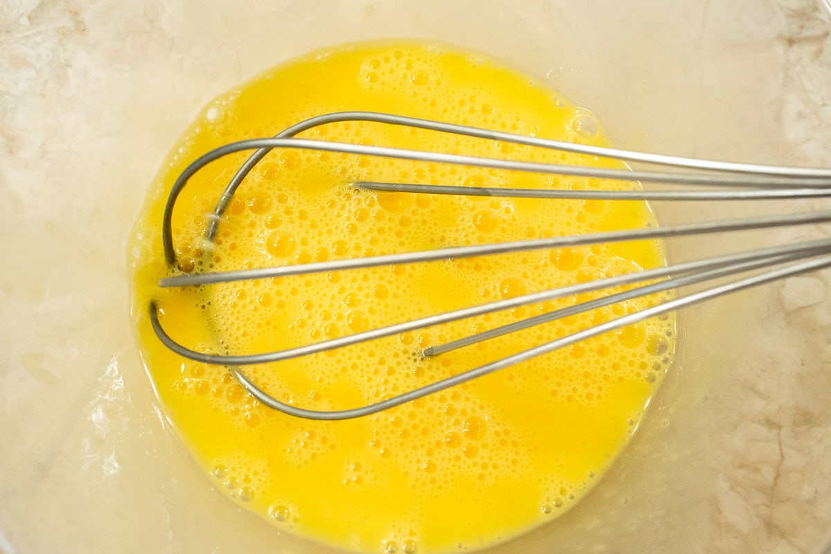 The eggs and yolks are whisked until no white are showing.