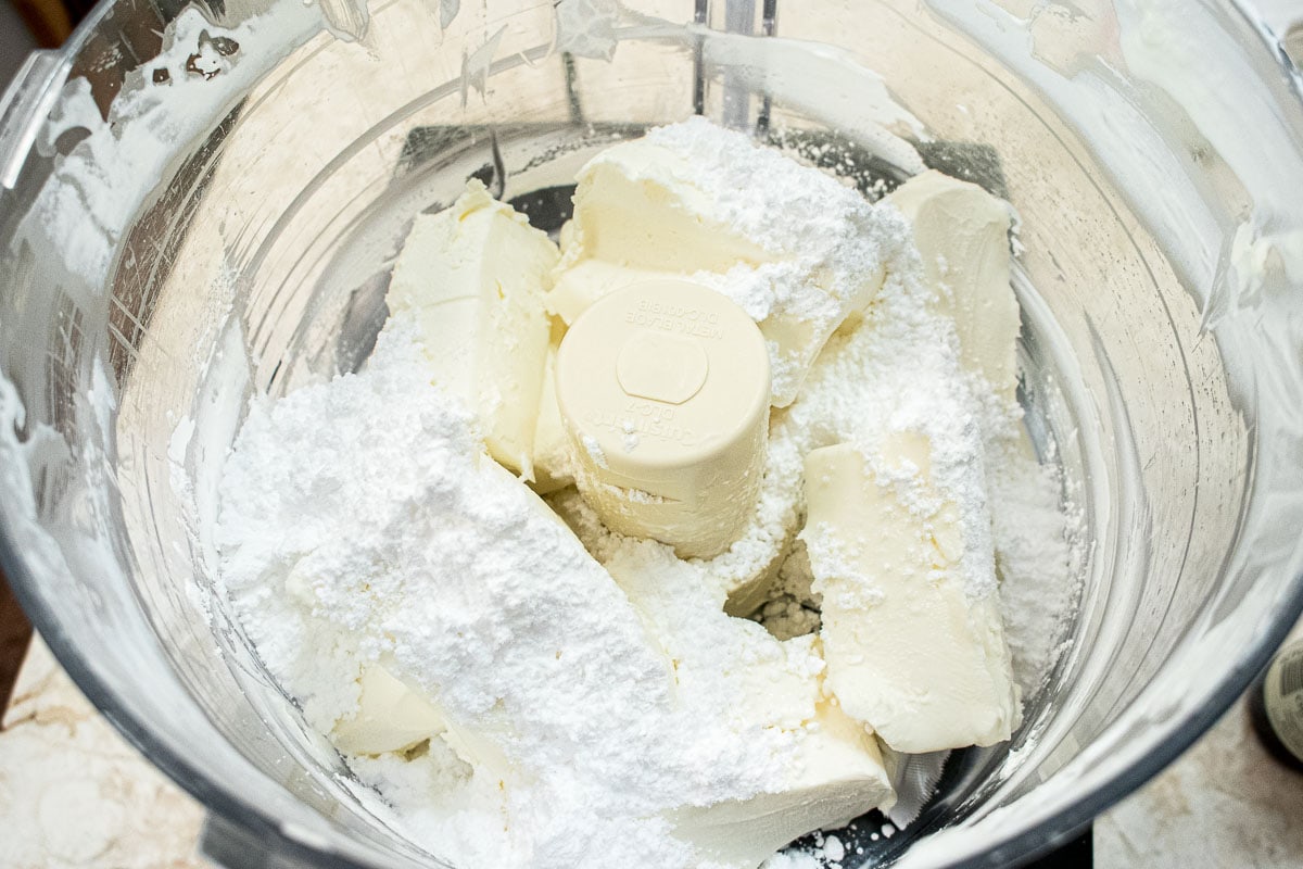 The cream cheese and powdered sugar are in the processor bowl.