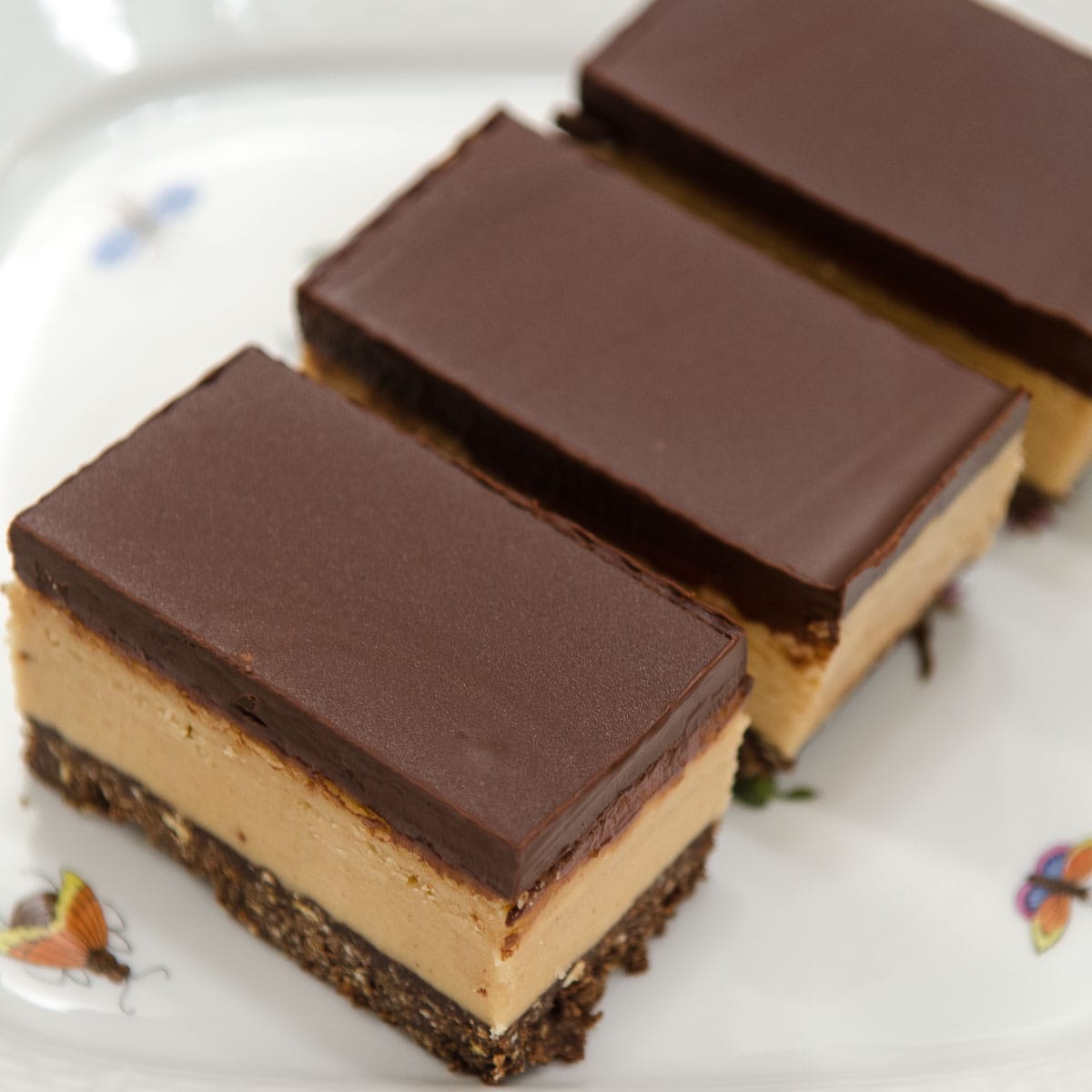 No Bake Peanut Butter Bars on a white plate with bees on it.