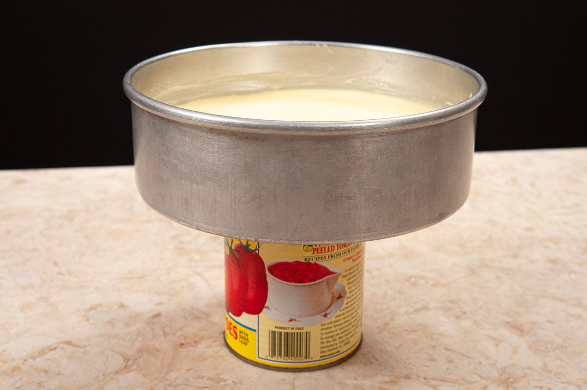 The pan with the cake is place on a wide can.