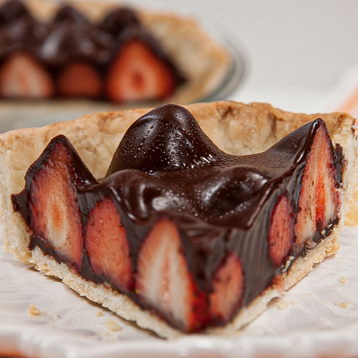  A slice of the Chocolate Strawberry Pie on a white plate.
