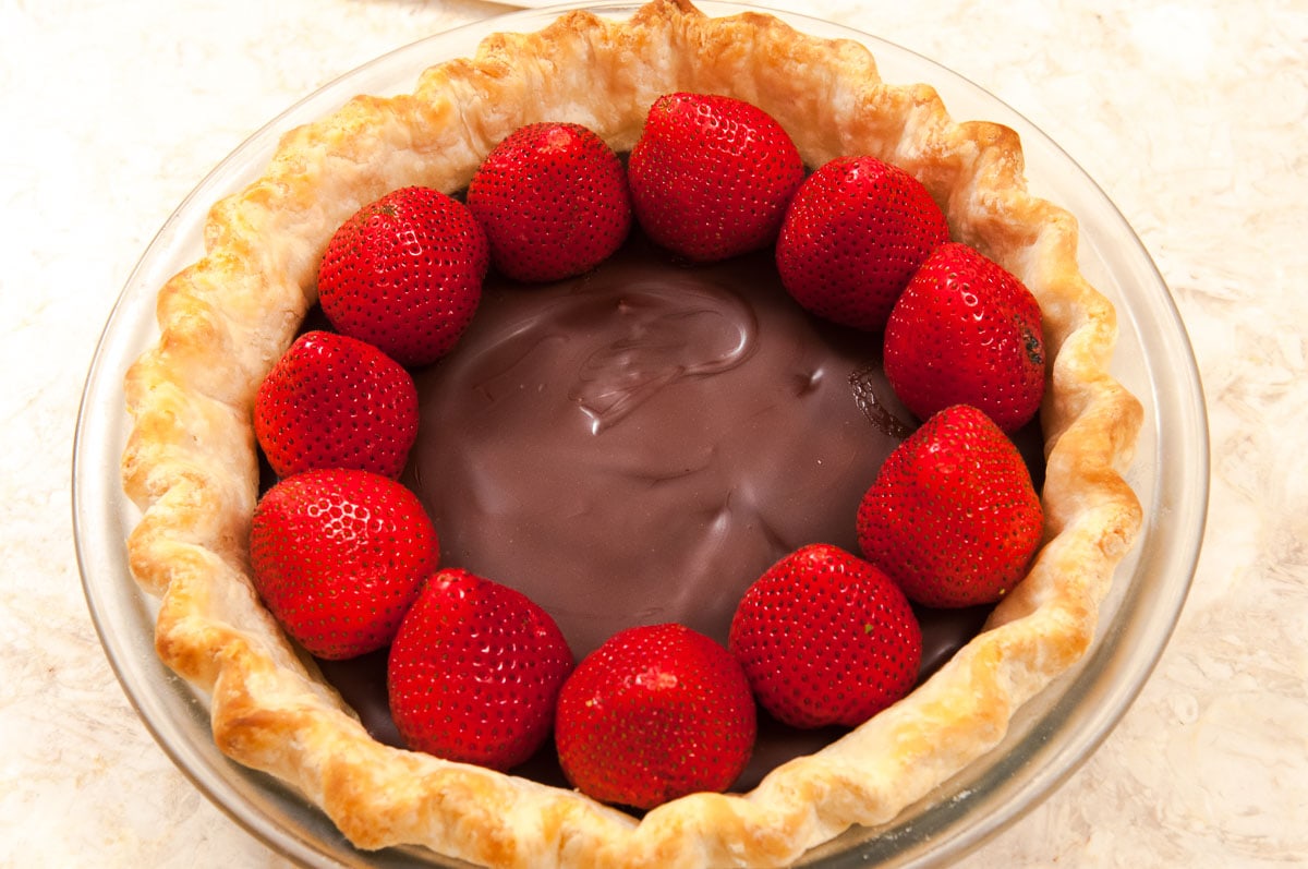 Strawberries are rimming the edge of the  crust.