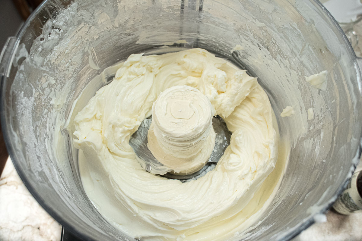 The heavy cream has been whipped in a processor bowl.