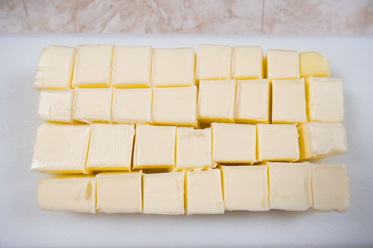 Cold butter is cut into pieces.