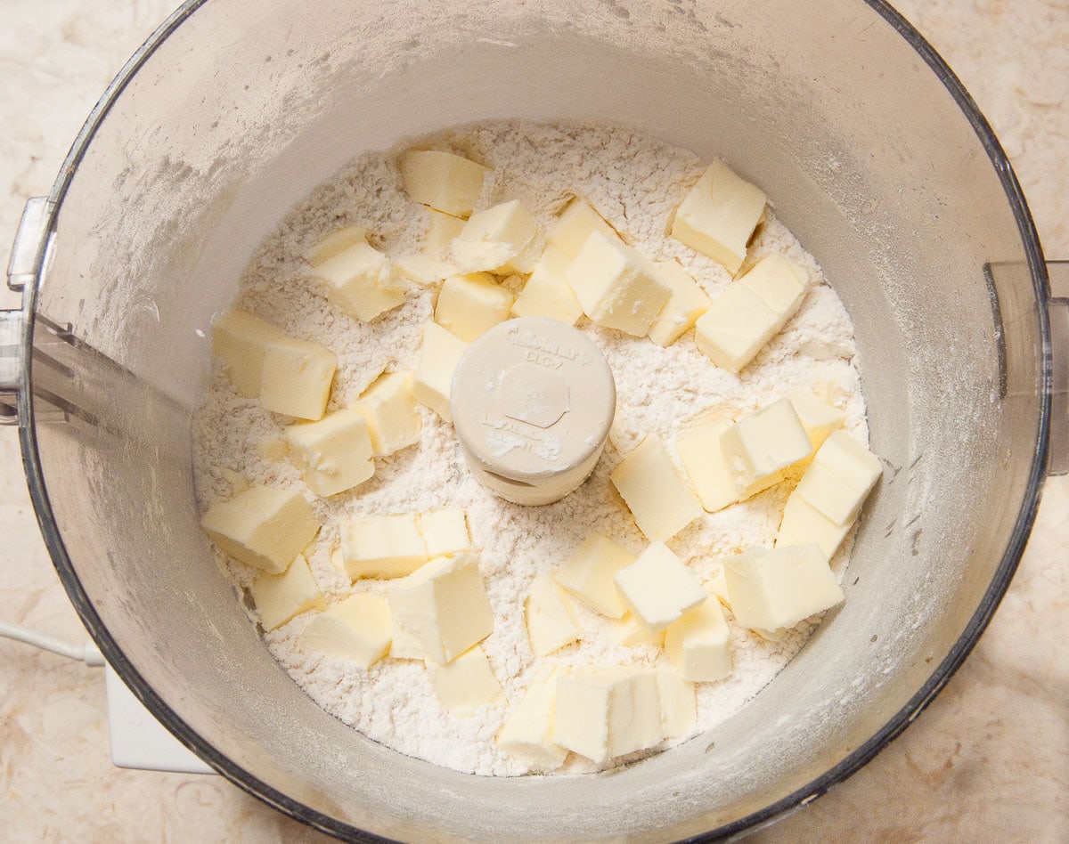 The butter is added to the processor with the dry ingredients.
