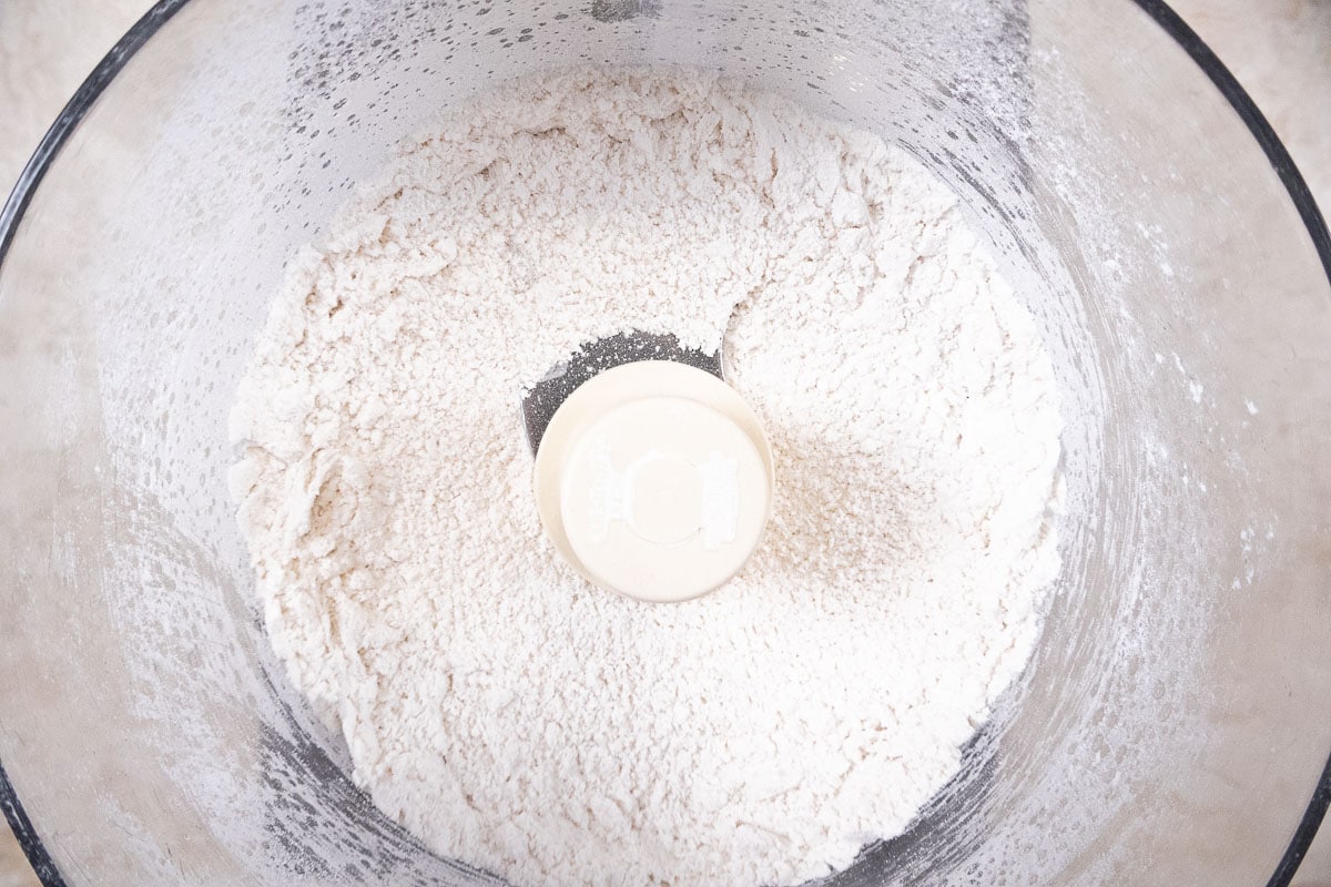 The dry ingredients in the processor are processed to combine them.