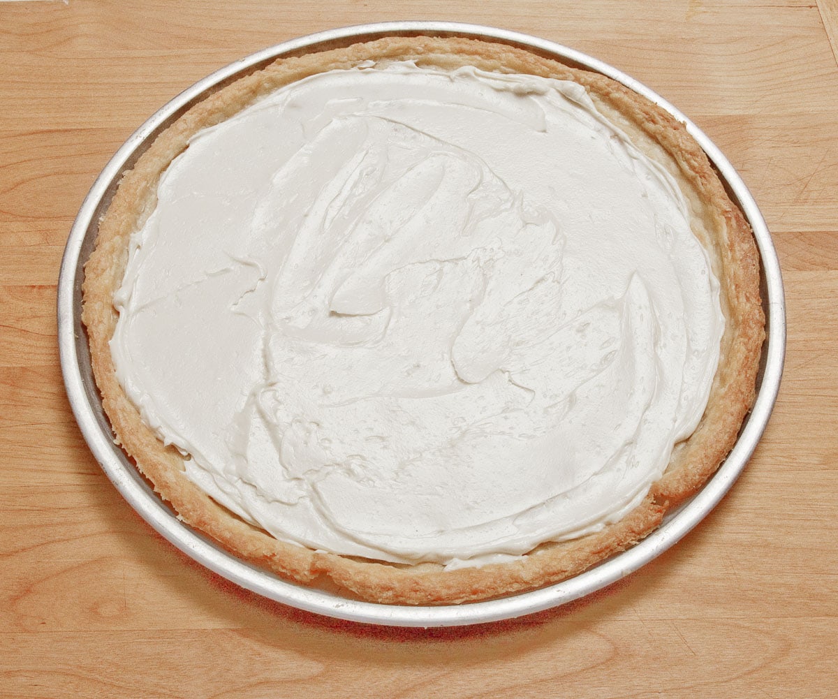 The goat cheese filling has been spread over the crust.