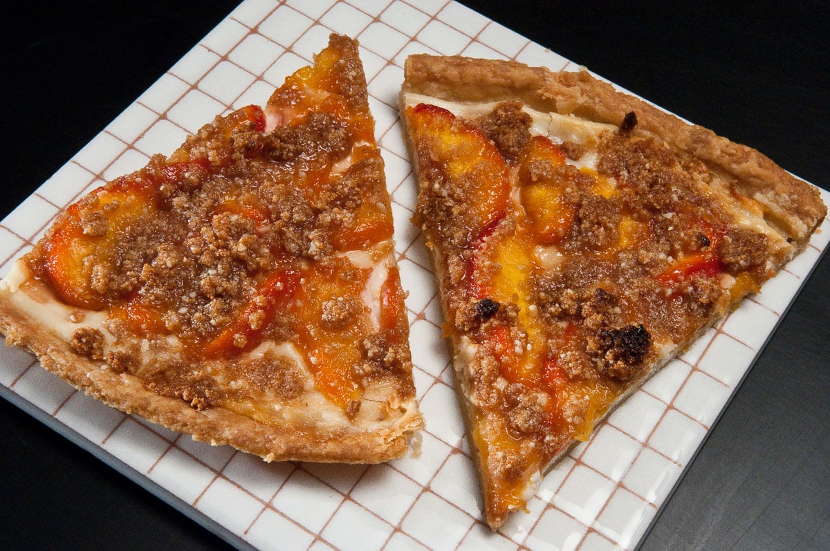 Two slice of the peach pizza on a plate.