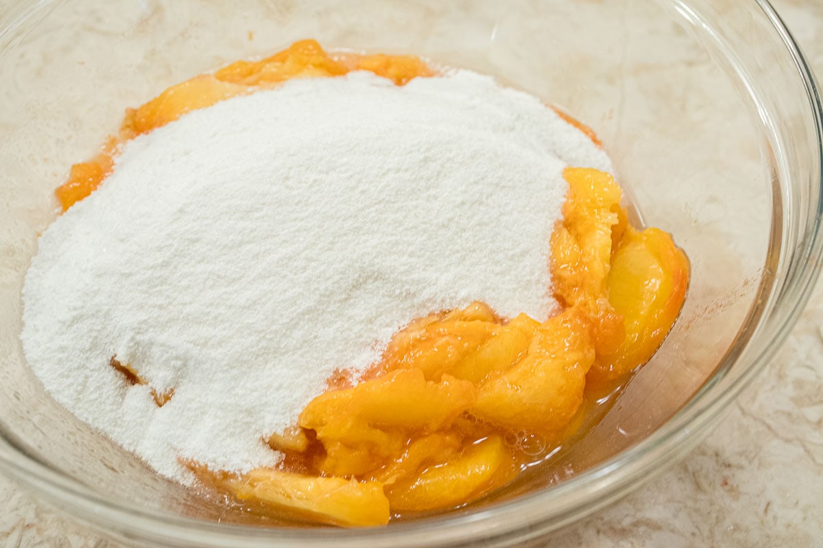 The peaches, flour and tapioca are combined in a bowl.