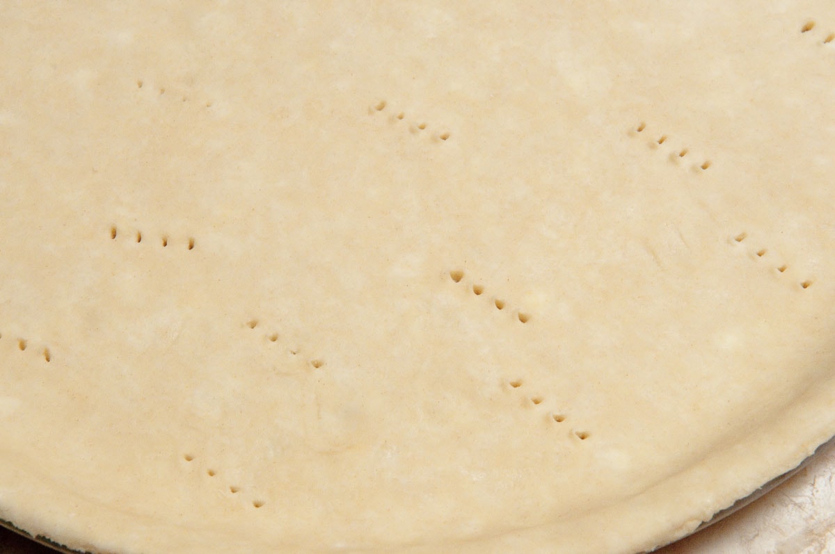 The crust is pricked with a fork to prevent it from  bubbling up during baking.