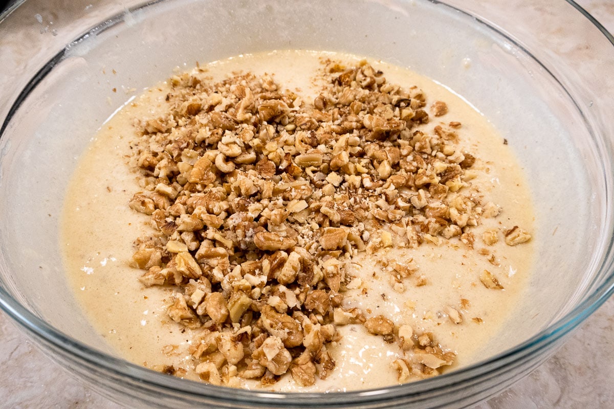 The walnuts are added to the bowl with the batter.