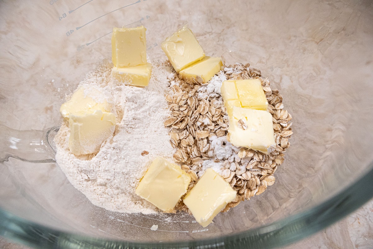 All the ingredients for the plum crisp are placed in the bowl of a mixer.