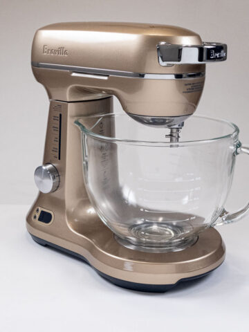 The Champage colored Breville Bakery Chef Mixer with a glass mixing bow.