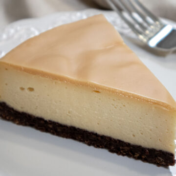 Slice of Bailey's Cheesecake on a white plate with a fork.