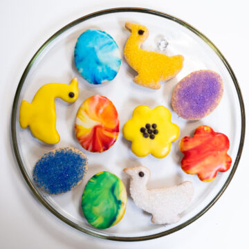 A platter of brightly Decorated Shortbread Cookies for Easter including ducks, flowers and Easter eggs.