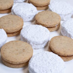 Rows of plain and powdered sugar Serbian Walnut Cookies on the diagonal are shown