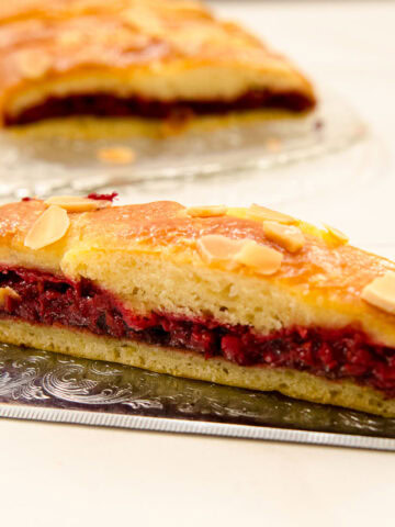 The opening photo for the Chocolate Raspberry Braid Recipe shows a slice of the braid on a silver cake server with the rest of the braid in the backgound.