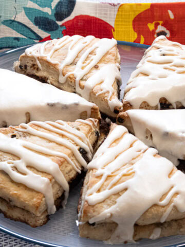 A plate of 6 Stuffed Buttermilk Scones on a blue rimmed plate with a multi colored napkin in the background.