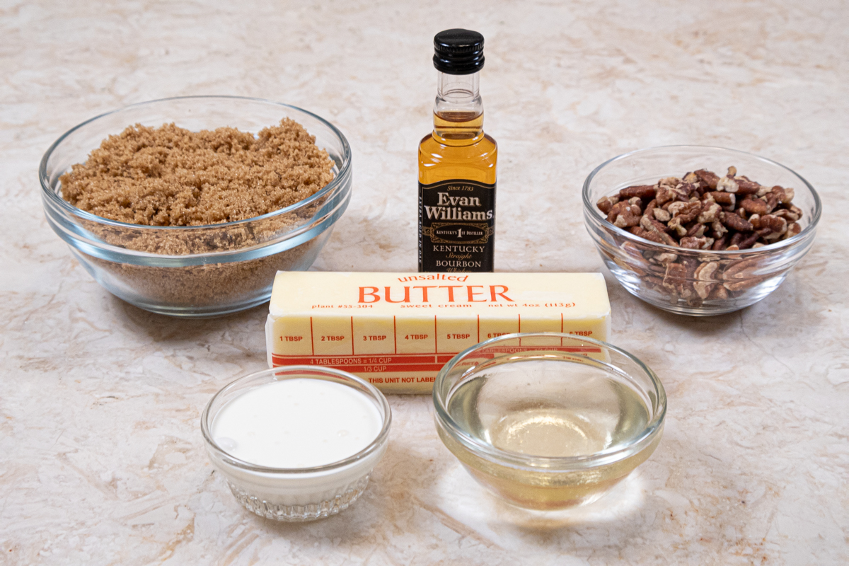 The Bourbon Pecan Sauce ingredients are brown sugar, bourbon, toasted pecans, unsalted butter, cream, and corn syrup.