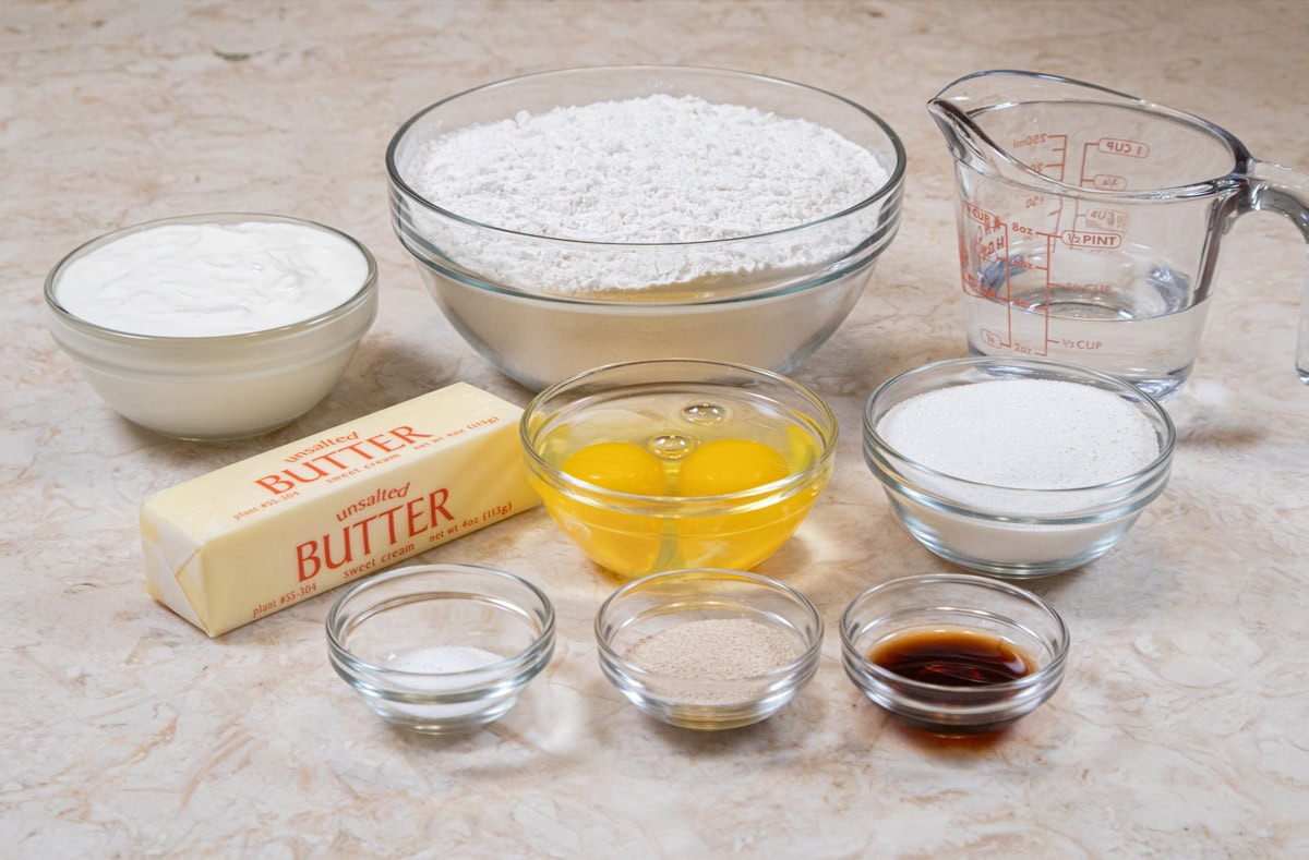 The ingredients for the Best Cinnamon Crunch Rolls Recip include, all-purpose flour, sour cream, water, unsalted butter, eggs, granulated sugar, salt,  yeast, and vanilla.