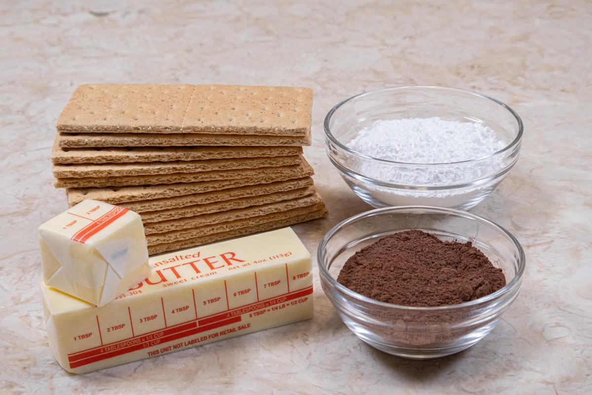 The crust ingredients include graham crackers, powdered sugar, cocoa powder and unsalted butter. 