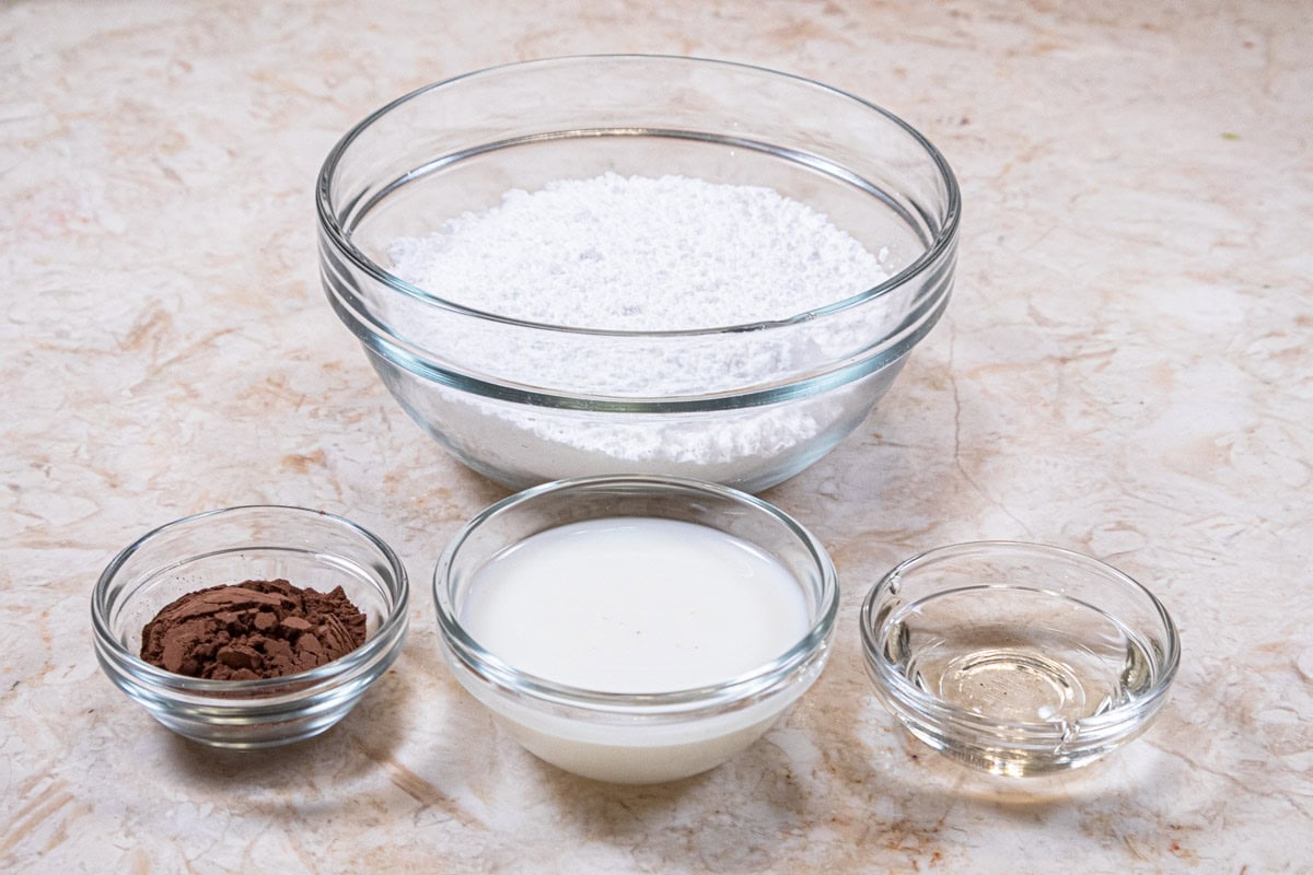 Ingredients for the mock fondant are powdered sugar, milk, cocoa, and corn syrup.
