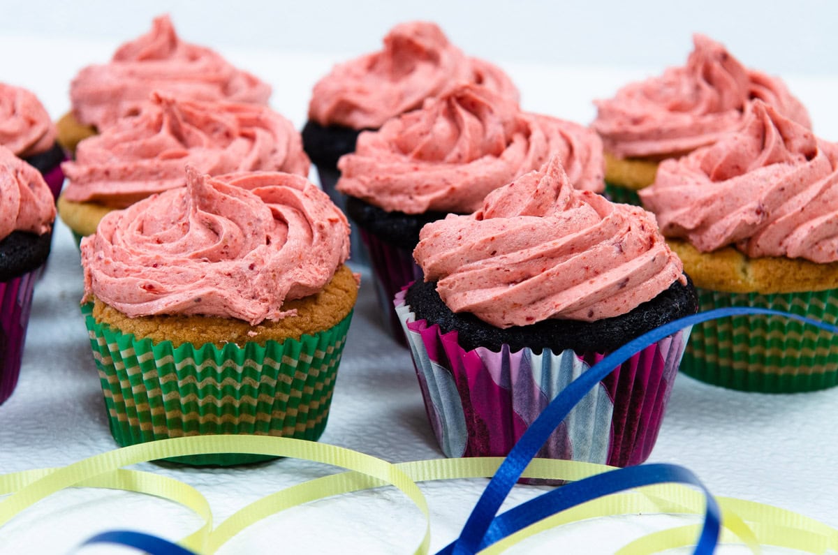 Strawberry Buttercream tops cupcakes with fest ribbons around, 