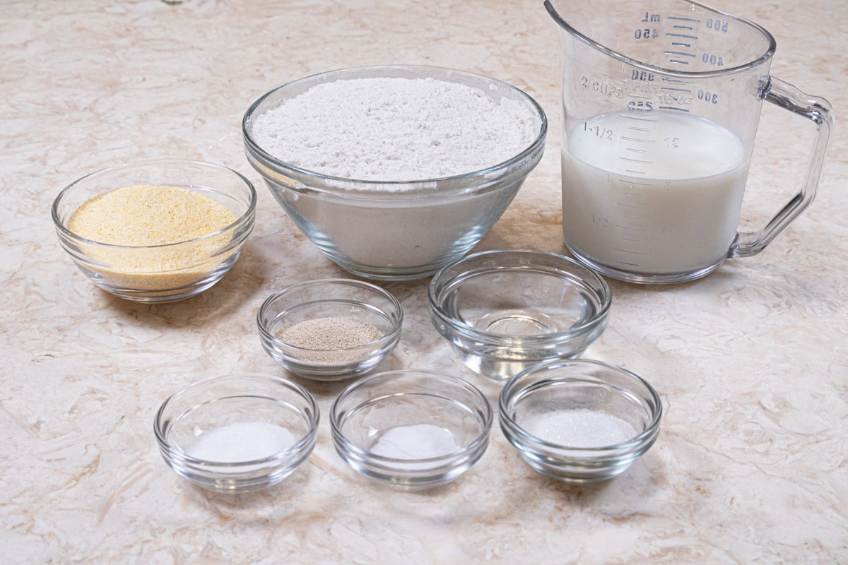 Ingredients for the English Muffins include, all-purpose flour, milk, yeast, water, salt, sugar, yeast and cornmeal to dust the pan.