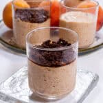 A picture of a single Peach Mousse with Cinnamon Crunch on a clear plate with a tray in the background,