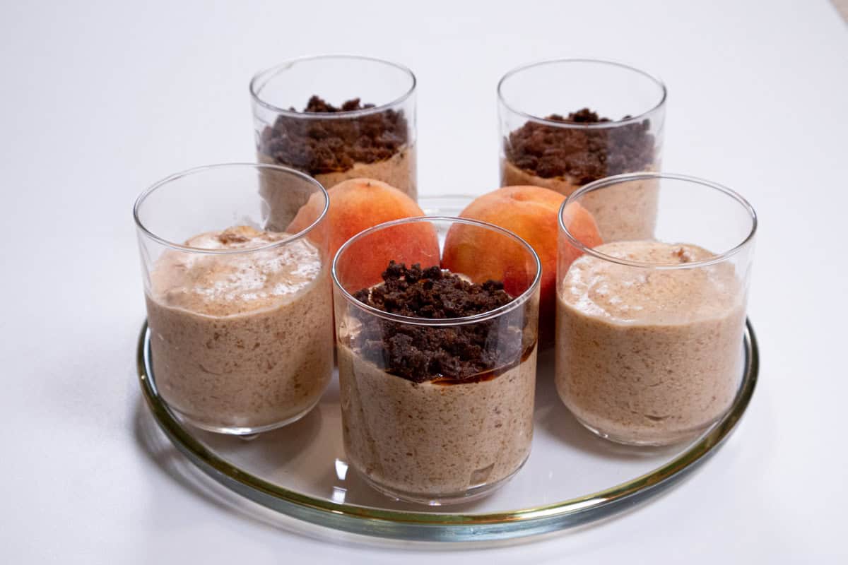 A tray of Peach Mousse on a gold rimmed tray with peaches in the middle. 