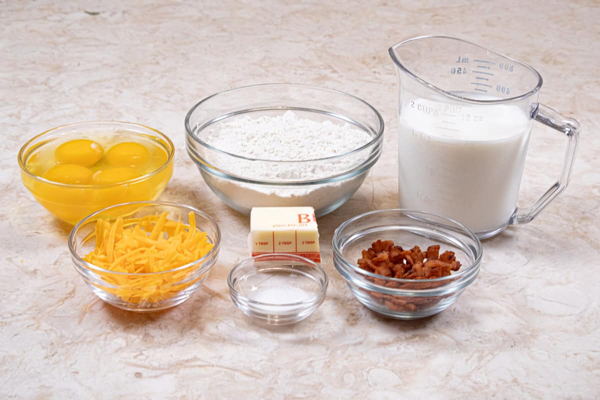 Ingredients for the pOpovers include eggs, milk, butter, bread flour, salt, cooked bacon and cheddar cheese..