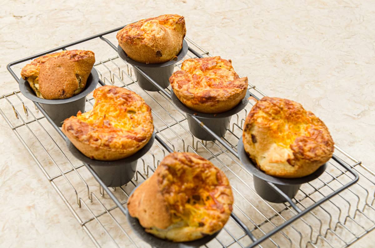 Here are six popovers in their pan on a cooling rack. 