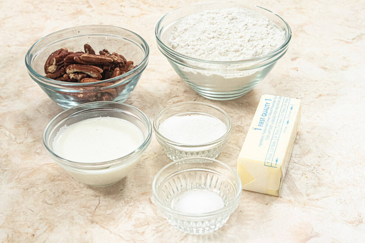 The ingredients for the crust are toasted pecans, all-purpose flour, granulated sugar, salt, unsalted butter, and heavy cream. 