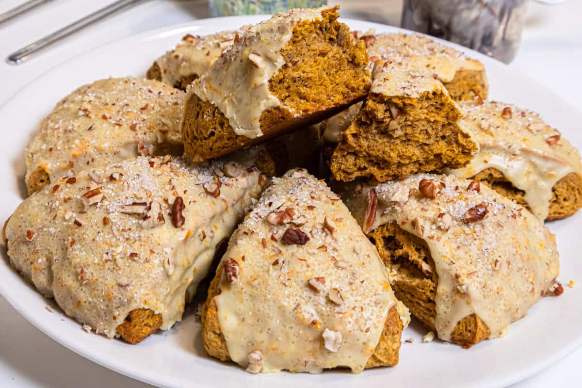 A plate of scones with one on top broken open to show the interior of the scone.