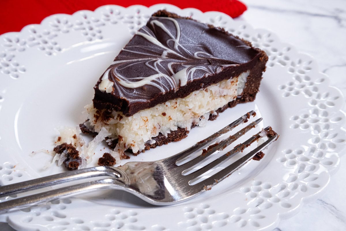 This photo shows a slice of the tart,  partially eaten, on a white plate with a red napkin in the background and a fork on the plate.