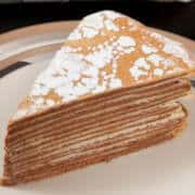 The 27 Layer Tuille Torte sits on a beige and silver plate.