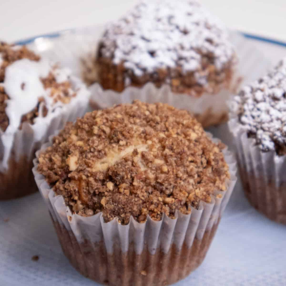 A Banana Streusel Muffin on aplate with others behind it. 