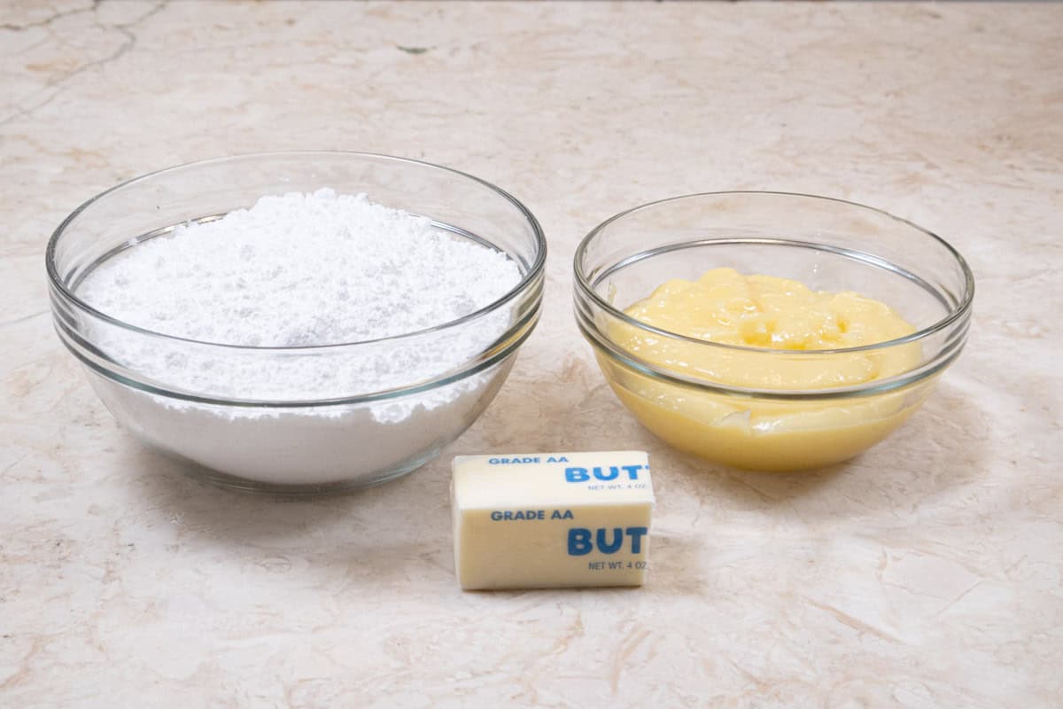The three ingredients for the frosting are powdered sugar, lemon filling and unsalted butter.