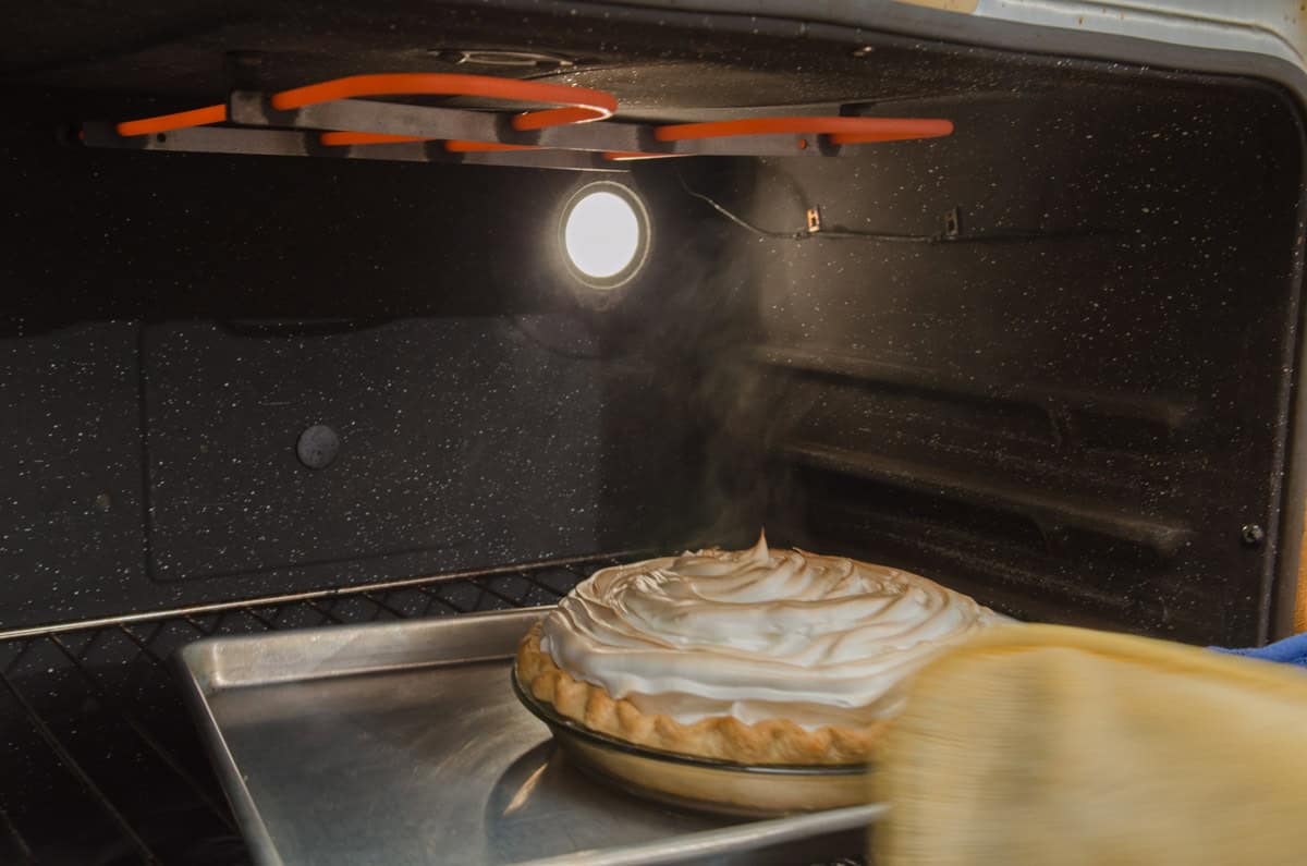 The tray is in the oven under the broiler with the meringue browning. 
