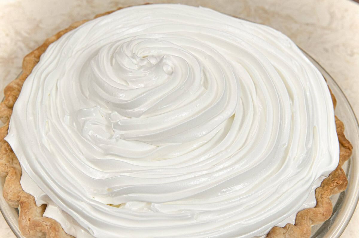 Meringue is piped onto the filling completely. 