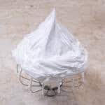 A whisk is upside down holding stiffly beaten meringue in a sharp peak.